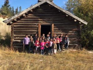 Kids in front of log cabin
