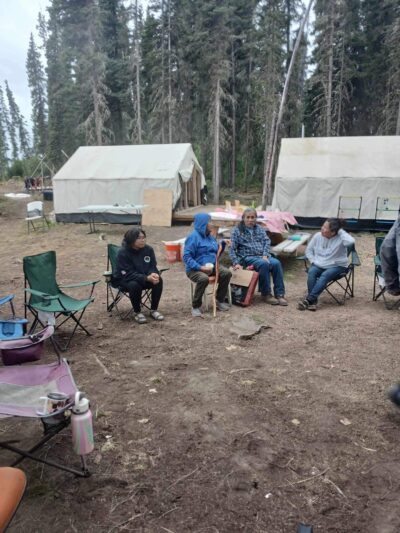 Campers sitting in front of tents